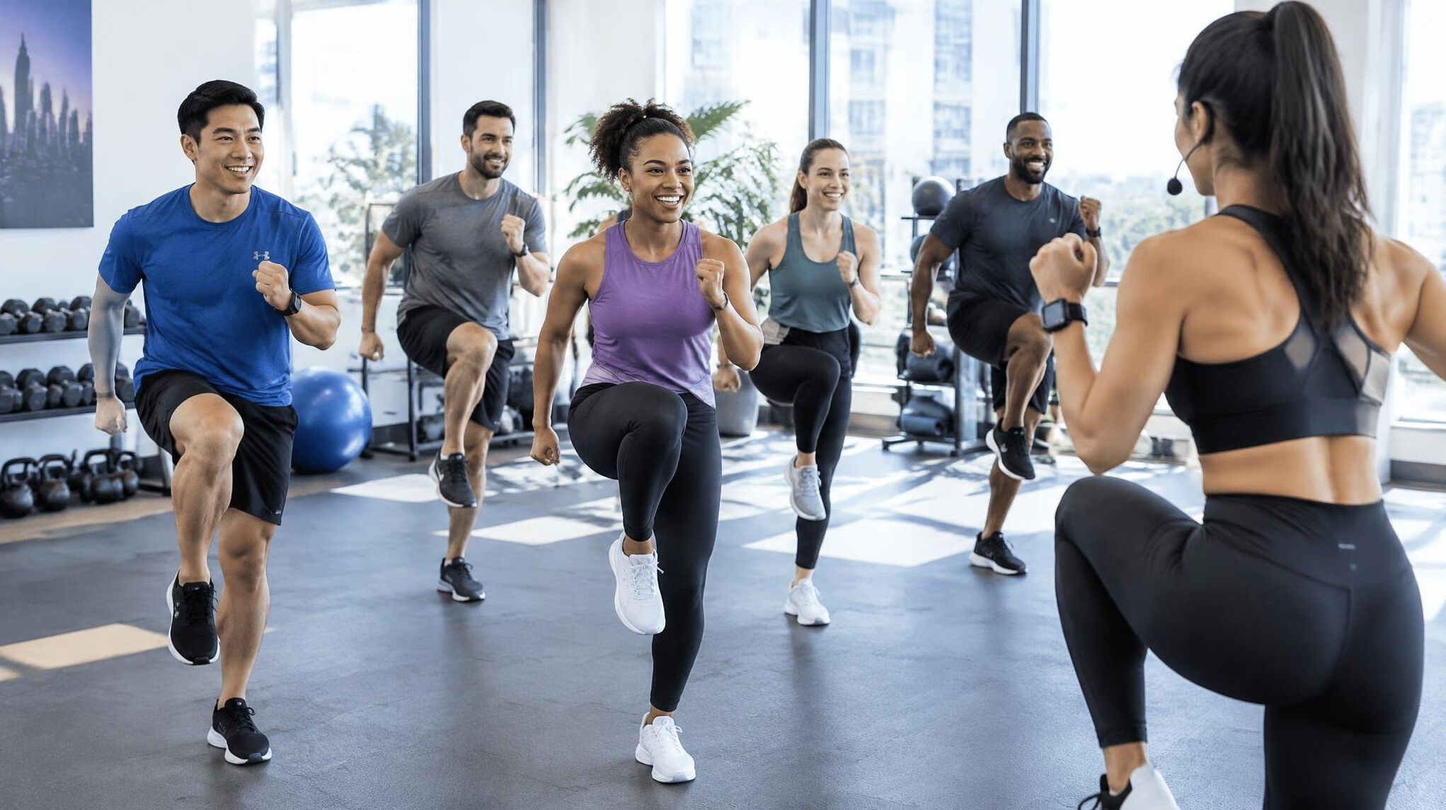 Group fitness class with employees exercising together led by a trainer