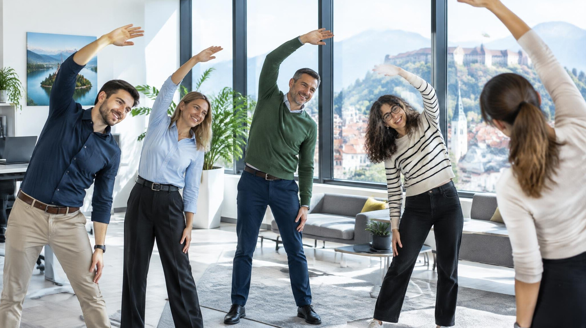 Colleagues stretching together during a workplace wellness break in a bright office
